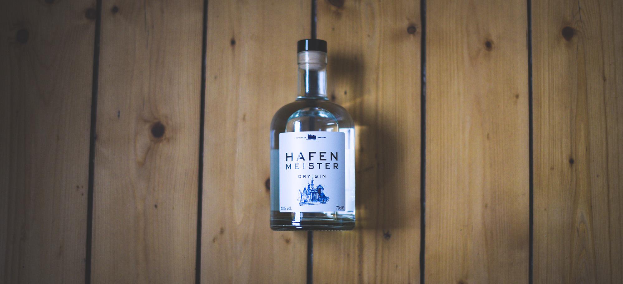 Nahaufnahme von Hafenmeister Dry Gin in einem Glas, eingefangen bei stimmungsvollem Barlicht, Kreation der Mercurius Drinks Company, mit Espresso und Pfeffernoten für einen unverwechselbaren Geschmack